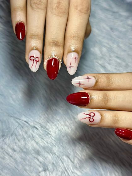 The combination of glossy red and soft nude with fine-line art creates a sophisticated and trendy look.