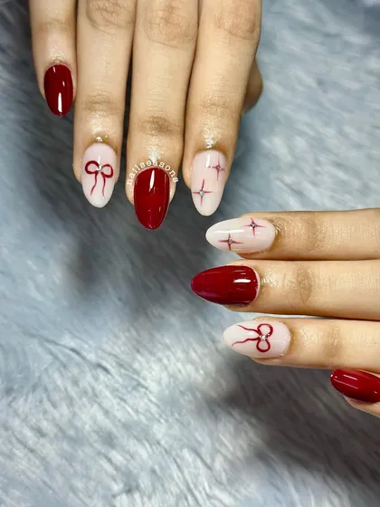 The combination of glossy red and soft nude with fine-line art creates a sophisticated and trendy look.