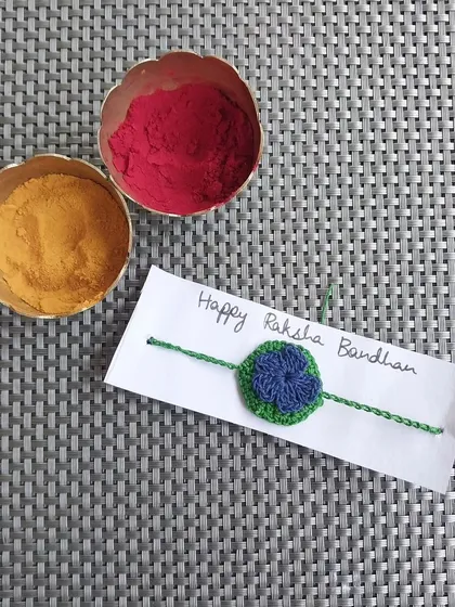 A dual-colored circular rakhi in blue and green.