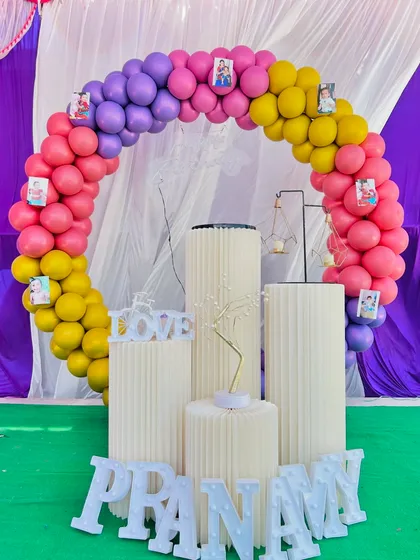 We can also add personal touches to your decorations, like hanging photos of the birthday person on the balloon arch as seen in this setup.