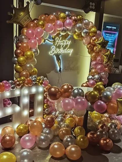 A glamorous ring decoration using a mix of metallic and chrome balloons in gold, rose gold, and silver for a 40th birthday.