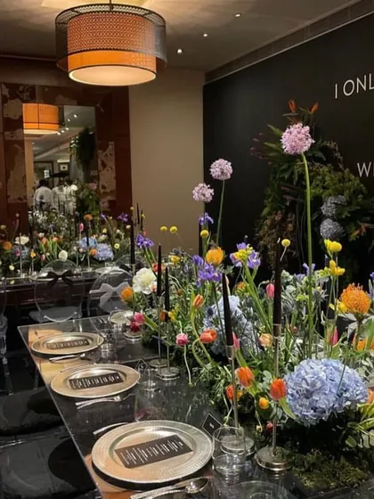 A closer look at the stunning floral centerpiece and modern place settings. Every detail is curated to create a sophisticated and cohesive dining experience.