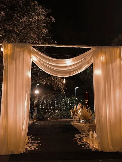 A beautifully draped entrance with soft, flowing fabric and warm string lights. This simple and elegant design creates a welcoming and intimate atmosphere for an evening corporate gathering or dinner.