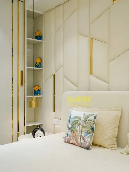 Detail is key in my designs. This shot shows the integrated vertical shelving next to the bed, a smart storage solution that keeps the space uncluttered while providing a place for personal decor. The gold accents tie into the headboard design.