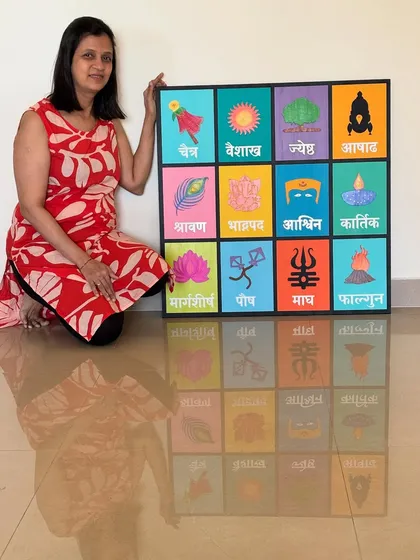 Another pose with the large Marathi calendar, showing its scale and vibrant presence.