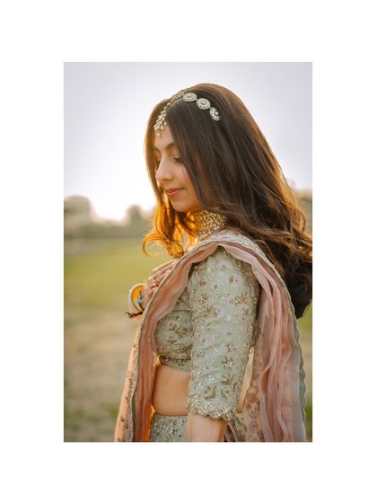 A close-up portrait of the bride in profile, with the sun creating a beautiful halo effect in her hair.