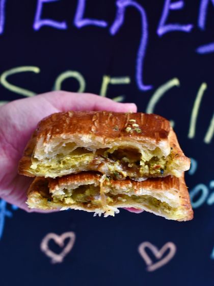 The cross-section of our Kasundi Chicken Pain Suisse. This savoury croissant pastry is filled with a tangy Bengali Kasundi mustard chicken, offering a unique and delicious flavour combination.