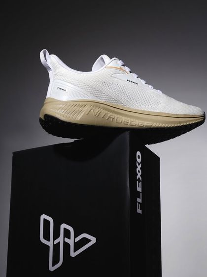 This shot places a white sneaker on a branded block, creating a heroic, elevated look. The dark, moody lighting adds a premium feel, perfect for a product launch.