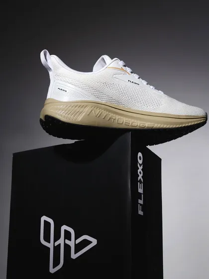 A hero shot of a white sneaker placed on its branded box. The dramatic, single-source lighting creates a premium, high-impact image that makes the product look powerful and desirable.