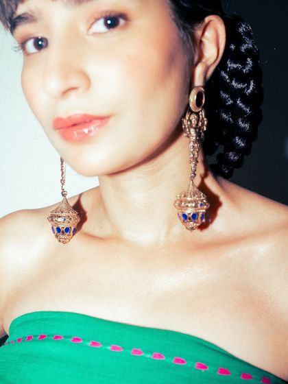 A close-up on the stunning statement earrings, which have a beautiful, temple-like structure.
