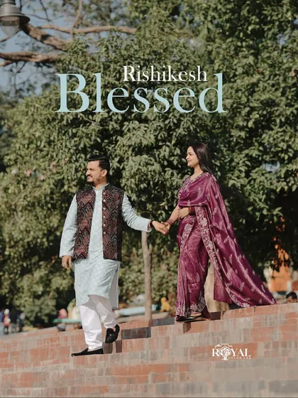 A graceful shot of a couple in beautiful traditional attire walking down the steps of a ghat, capturing a blessed moment.