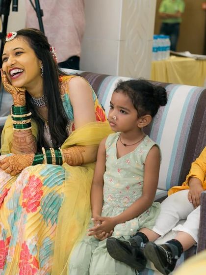 A candid moment of the bride laughing while seated next to the youngest guests.