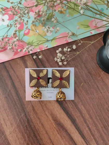 These square gotapatti earrings with a classic jhumki drop are a popular choice. The design combines traditional gota patti work on a fabric base with an antique gold finish jhumki for an elegant ethnic look.