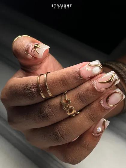 The complete look of the abstract gold swirl manicure. The design flows across each nail, creating a cohesive and elegant set that is both modern and timeless.