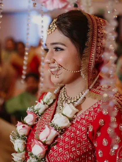A candid shot of the bride during her ceremony. The updo remains perfectly in place, adorned with a garland, showcasing the durability and grace of the hairstyle.