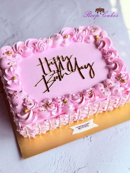 A pretty pink sheet cake with decorative piping and golden sprinkles for a touch of sparkle.