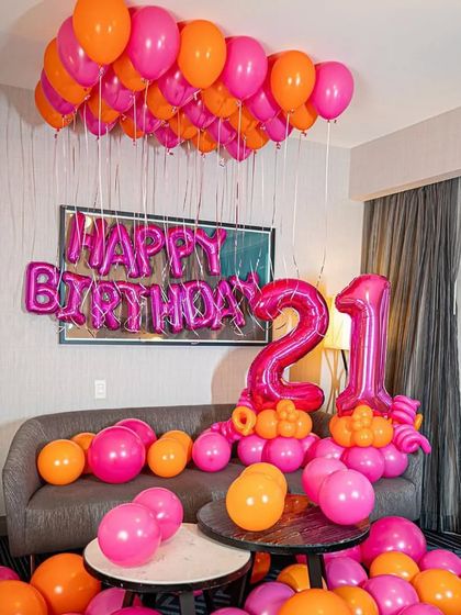 A wider view of the pink and orange 21st birthday party, showing how the decor fills the living room.