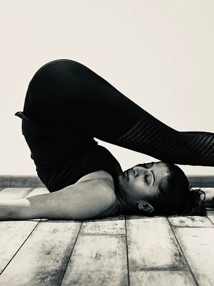 Halasana, or Plow Pose, is a deep forward-bending inversion that stretches the entire spine and shoulders. This pose is part of our 'Slow and Strong' practice, designed to build fluidity and strength.