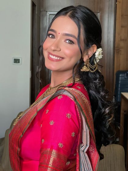 A happy and confident portrait. The makeup is minimal yet effective, creating a timeless and elegant South Indian bridal look.