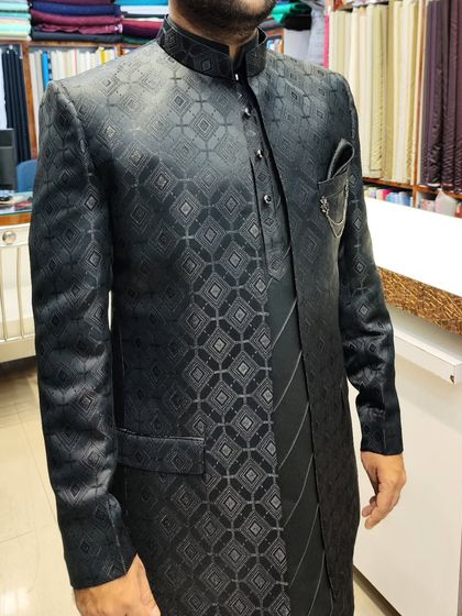 A sleek, black-on-black open shrug and jacket set. The geometric pattern on the jacquard fabric adds a subtle texture, perfect for an evening event.