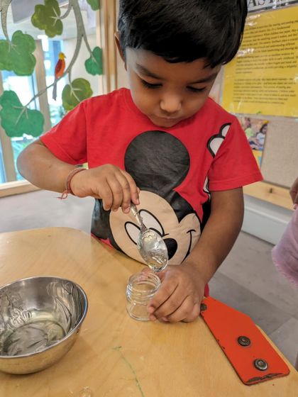 For Mother's Day, children engaged in a multi-sensory culinary project. They scooped aloe vera gel and crushed rose petals to create a special gift. This practical life skill activity also involves measuring, pouring, and mixing.
