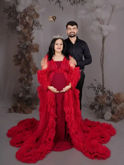 We believe every mother is a queen, and this portrait session is designed to celebrate that. Dressed in a magnificent red gown against a floral backdrop, this mom-to-be radiates strength and beauty, creating a regal and unforgettable maternity portrait.