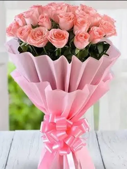 A beautiful bouquet of two dozen pink roses. The pleated pink paper wrapping adds texture and volume, making the arrangement look even more lush.