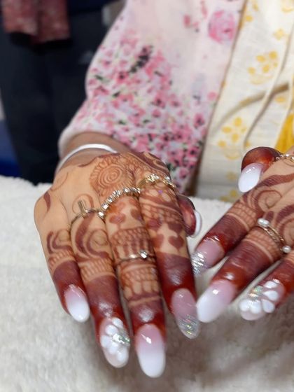 A beautiful set for a bride. These nails feature a white ombre, silver glitter, and delicate 3D white flowers to perfectly match a wedding look.