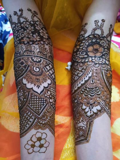 The back of the arms for bride Aqsa's mehendi. The design features architectural domes and intricate checkerboard fills.
