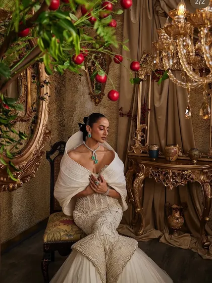 The ivory hooded gown, a piece of couture that speaks without shouting, captured in a moment of quiet contemplation.