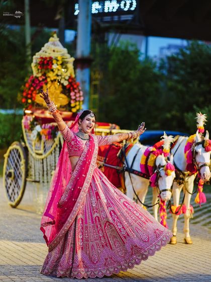 A princess moment for the bride. She twirls with joy in front of the beautifully decorated wedding chariot, a perfect blend of tradition and modern fairytale.