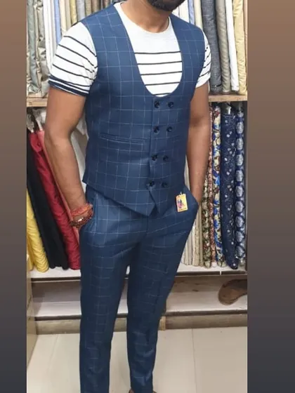 This client is wearing a custom made two piece set with a double breasted waistcoat and matching trousers in a blue check fabric. It's a modern way to wear a waistcoat.