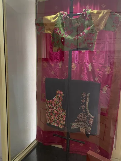 A display at my studio featuring a ready-made mirror work blouse and unstitched blouse pieces with floral and Kasuti embroidery.