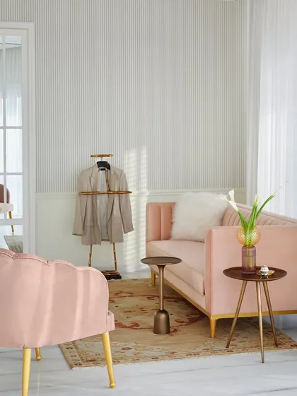This bedroom for a young lady embraces her love for blush pink and French-inspired design. The space is a delicate balance of playful sophistication, with soft textures, pinstripe wallpaper, and elegant furniture creating a light, airy, and personal sanctuary.