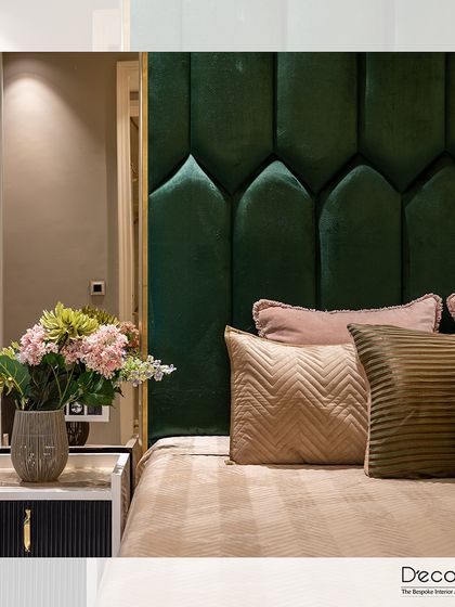 Indulge in luxurious comfort. This serene bedroom design blends plush textures, like the emerald green arched headboard, with elegant details, creating the perfect haven for rest and relaxation.