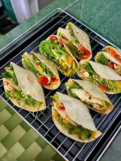 An array of homemade taco-style wraps ready to be baked. Filled with either chicken or veggies, these are a fun, healthy, and customizable meal for the whole family.