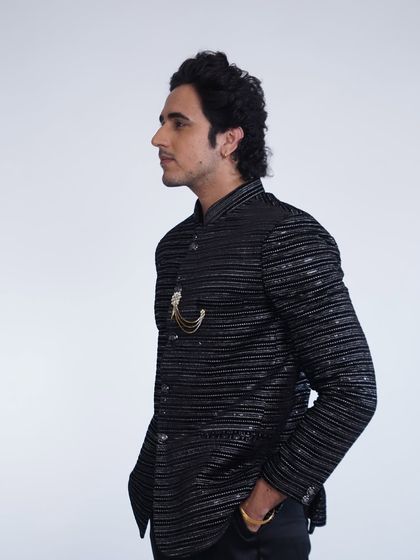 A side profile of our black striped bandhgala jacket. The subtle shimmer and sharp tailoring make it a sophisticated choice for any formal event.