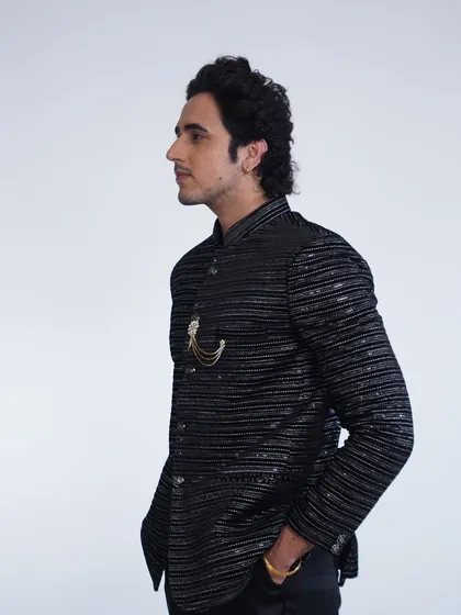 A side profile of our black striped bandhgala jacket. The subtle shimmer and sharp tailoring make it a sophisticated choice for any formal event.