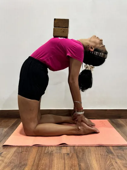 In this variation of Ustrasana (Camel Pose), blocks are placed on the upper back to provide feedback. This encourages the practitioner to lift and open the thoracic spine rather than collapsing in the lower back.