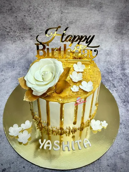 The full view of the white and gold drip cake, a simple yet stunning design for an elegant birthday celebration.