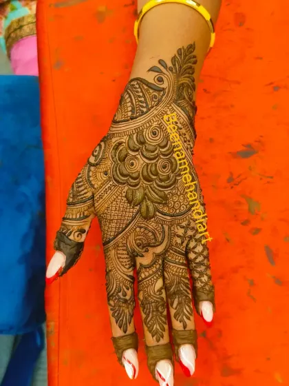 A full-hand design with a beautiful peacock and dense floral patterns.