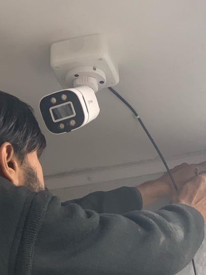 A technician at work, installing a camera with precision. We guarantee a professional job every time.