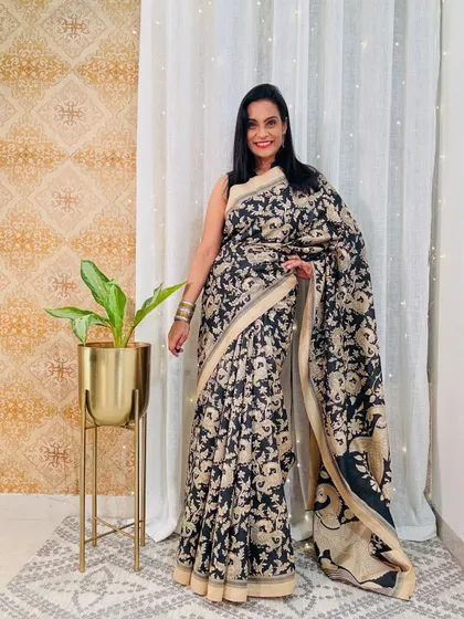 This black and beige Kalamkari-style printed saree is a sophisticated and artistic option for office wear. The intricate design gives it a very premium look.