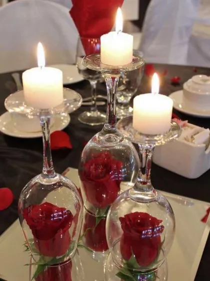 A creative and elegant centerpiece idea. I placed red roses inside inverted wine glasses and topped them with candles to create a unique and stunning focal point for the dinner table.