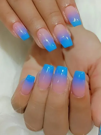 A bright and fun blue-to-pink ombre on square-shaped acrylic nails, a playful and eye-catching color combination.