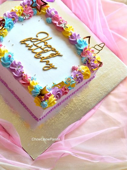 A corner detail of the unicorn sheet cake, showing the gold unicorn horn and butterfly toppers.