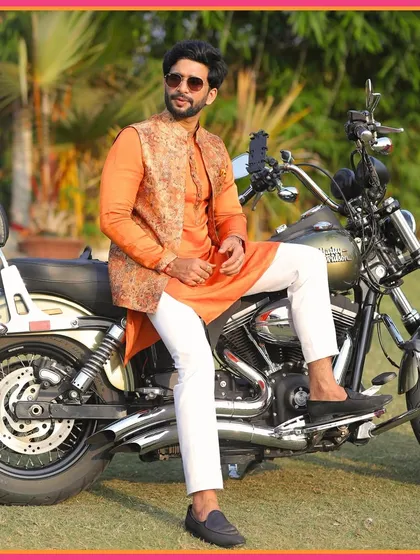 A groom in his element. Anuj posing on a Harley Davidson at his Mehendi, adding a touch of cool swagger to the traditional event.