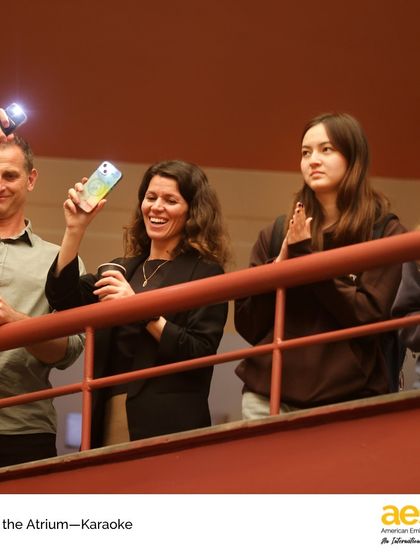 The audience cheers on a performer with phone flashlights during karaoke night. There's always an encouraging crowd at our arts events, making it a safe space for students to take the stage.