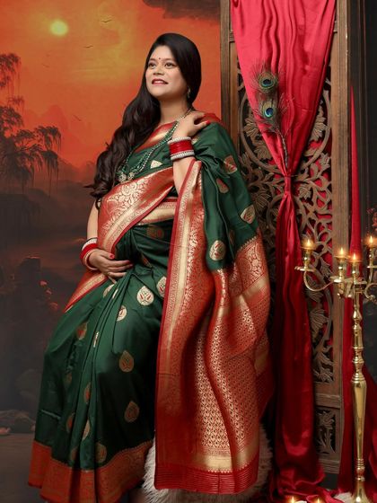 The Indian look is one of the best for a maternity shoot. This mom-to-be looks absolutely divine in a dark green silk saree with a red border, exuding grace and tradition.