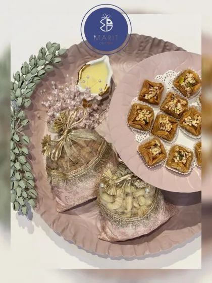 A beautifully crafted platter with dry fruit 'potlis' and sweets. This arrangement, with its soft pink tones and delicate details, brings a touch of magic to any celebration.